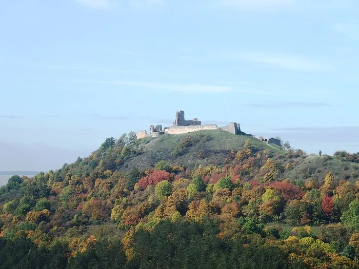 Branč Castle ruins on a forested hill in autumn