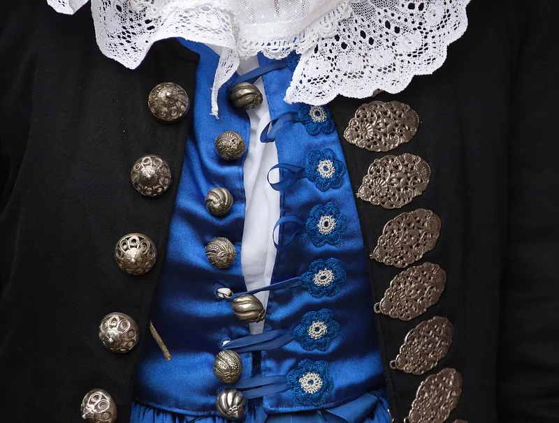 Detail of a Slovak folk costume with embroidery and silver buttons