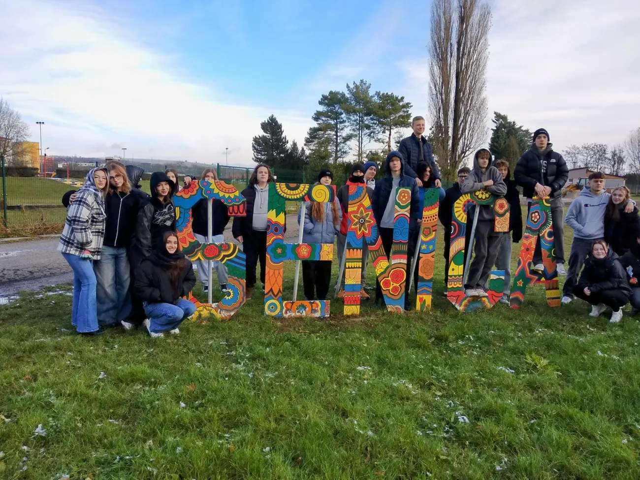 Our students outdoors next to large hand-painted letters