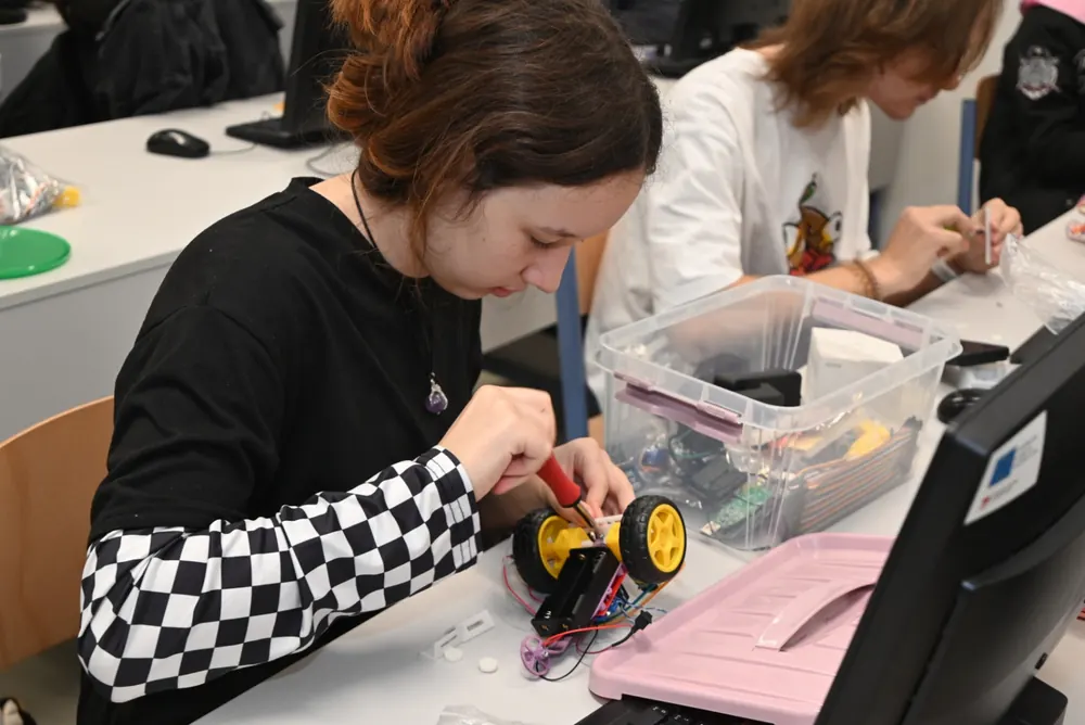 A student assembling a small robot